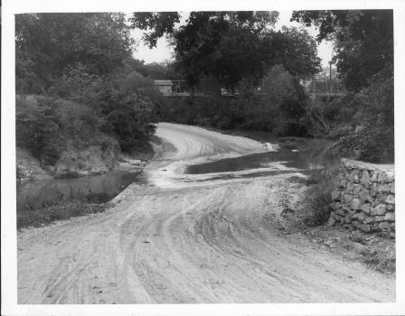 Sycamore Creek (Fort Worth, TX) overflowing across road, photograph date 5-1-1929