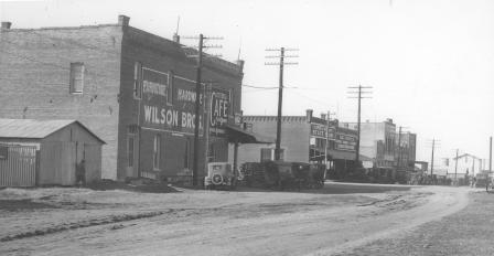 Main Street, Burleson, Texas: Wilson Brothers Furniture, Etter's Cafe, Farmers and Merchants Bank, Big Flour Company, Model-T cars parked along street, 08/12/1929
