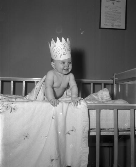 New Year baby, posed standing in crib and wearing a crown, Arlington, Texas
