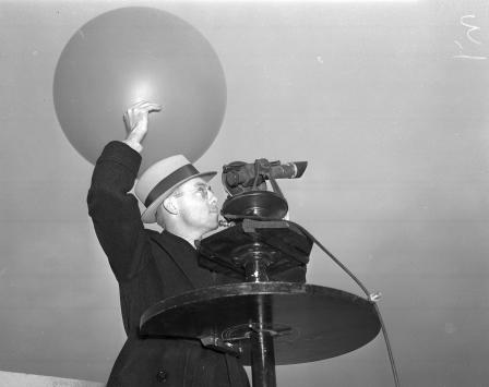 Roland Mills, assistant weather observer, about to release a balloon to determine wind direction and velocity at Fort Worth Muncipal Airport, 01/04/1938