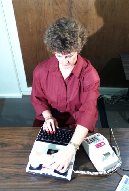 Paulette Lyons uses a  phone device for deaf customers; TTYs (teletypwriters) make it possible for the hearing-impaired to communicate by phone, 03/27/1989