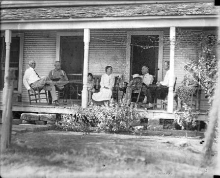 Amon G. Carter and others sitting on a front porch