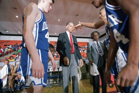 Dunbar High School basketball coach Robert Hughes with team during a game, Dunbar vs. Southwest High School
