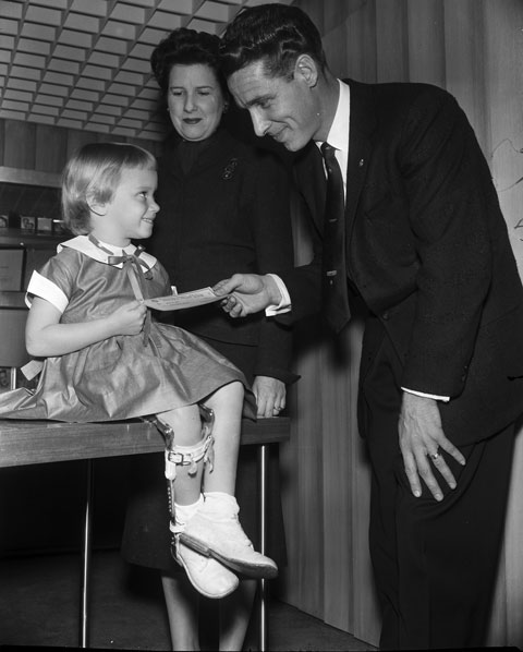 Barbara Gomez, four year old child with polio, exchanges a March of Dimes check for a penny piece of bubble gum