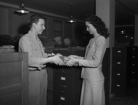 two people passing files