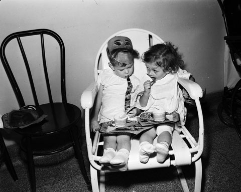 two toddlers sitting in a chair