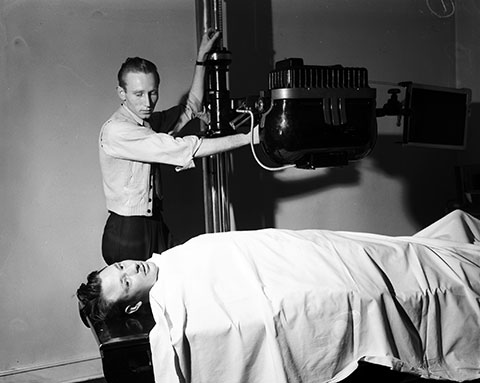 J. E. Martin lies on x-ray bed