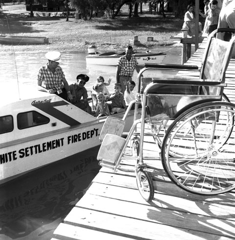 picnic with boat rides; an empty wheelchair is on the boat ramp