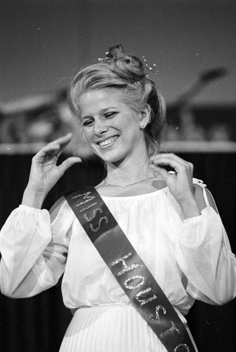 A young woman is wearing a sash that says Miss Houston.