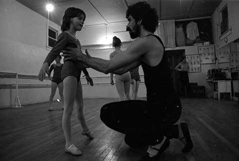 A man helps a girl with ballet.