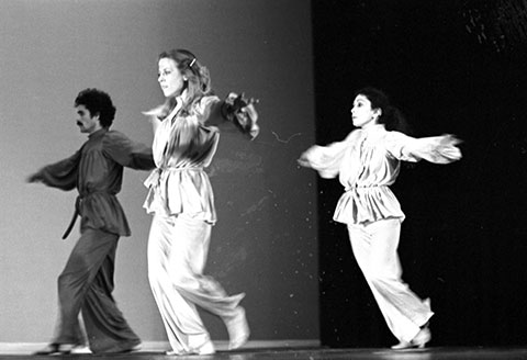 3 dancers, one male and two women, are on stage performing.