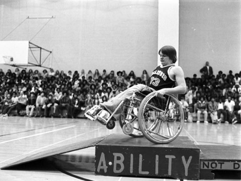 college student demonstrates his wheelchair skills to high school students