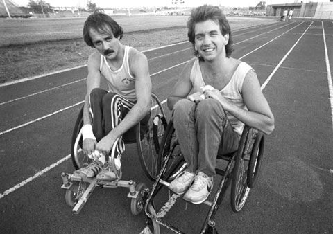 two men in wheelchairs on a racing track