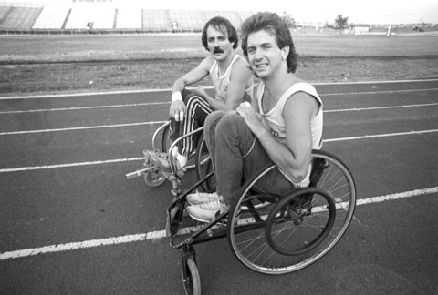 two men in wheelchairs on a racing track