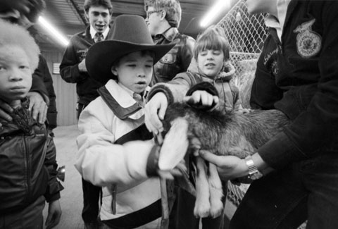 visually impaired children pet a goat