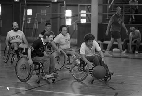 5 men playing wheelchair soccer