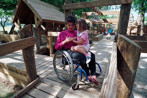 Mary Pat Hodge in a wheelchair with daughter, Melissa, sitting on her lap