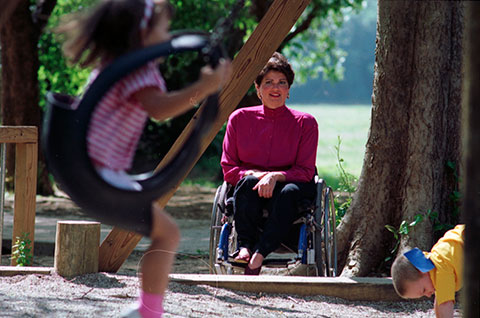 Mary Pat Hodge watching daughter, Melissa, on tire swing at Arlington's Sunrise Park