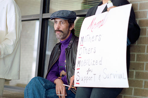 Brad Eddins, an AIDS patient at Fort Worth's John Peter Smith Hospital, watches protesters during a rally 