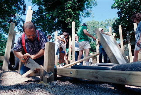carpenter Michael Hudon of Arlington (foreground) helps build playground with other volunteers in the background