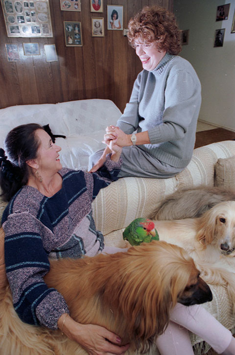 Natasha Noble and Linda Leithner sitting on couch with 2 dogs