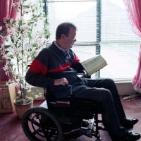 Rev. Robert Sorrels reading Bible in wheelchair