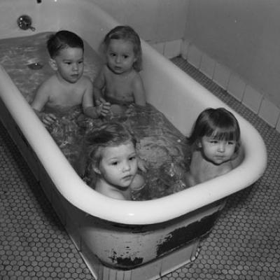 Four young polio patients are sitting in a bathtub