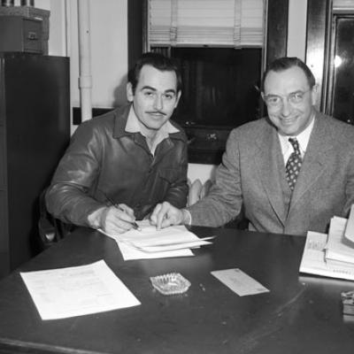 two men signing paperwork