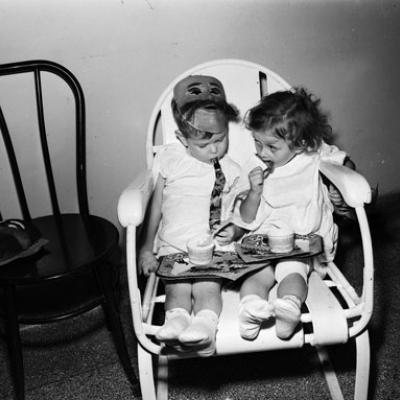 two toddlers sitting in a chair