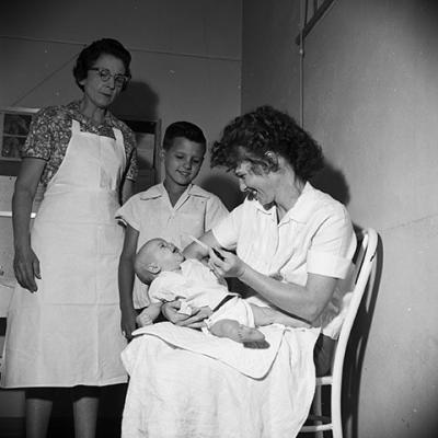 Mrs. Jimmie Cook uses eyedropper to administer the oral polio vaccine to 2-month-old Sherri Cook