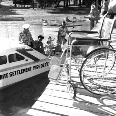 picnic with boat rides; an empty wheelchair is on the boat ramp