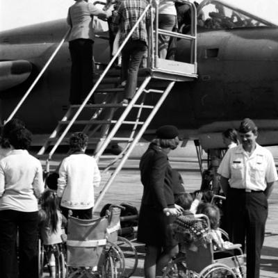 children, some in wheelchairs, are given a tour of an airplane