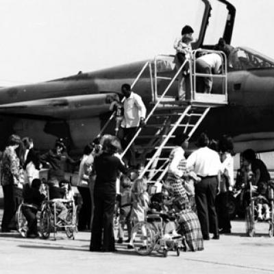 children, some in wheelchairs, are given a tour of an airplane