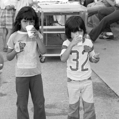 two children are drinking out of cups