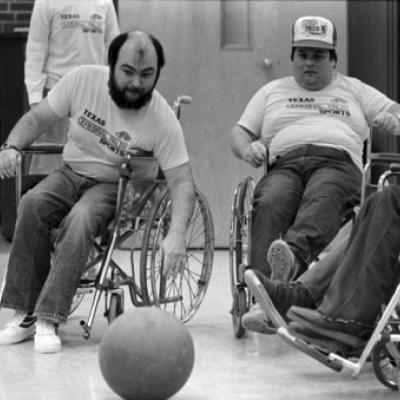 group of people in wheelchairs go after a ball