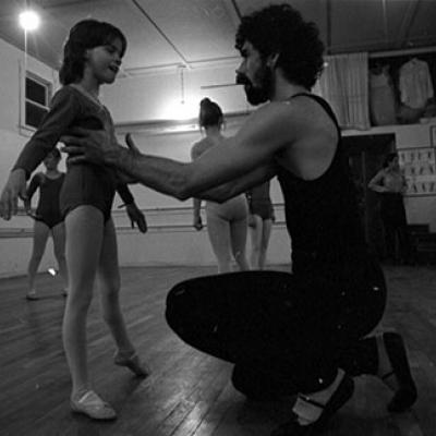 A man helps a girl with ballet.