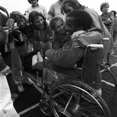  a Special Olympics wheelchair participant is congratulated by spectators and volunteers