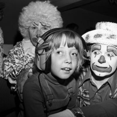 visually impaired child with three clowns at Shrine Circus using headphones that describe the action