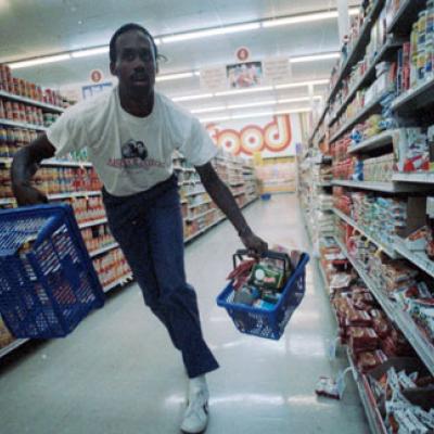 basketball player runs through supermarket holding grocery baskets