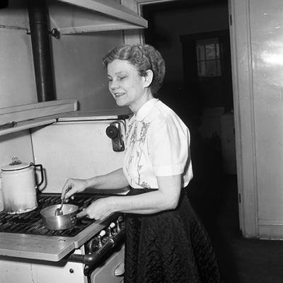 Mrs. Willie Fay Lewis, blind homemaker and former director of Fort Worth's Lighthouse for the Blind, tries cook stove 