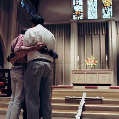3 people hugging during service consecrating AIDS Awareness Week at Fort Worth's St. Stephen Presbyterian Church