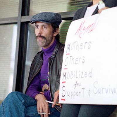 Brad Eddins, an AIDS patient at Fort Worth's John Peter Smith Hospital, watches protesters during a rally 