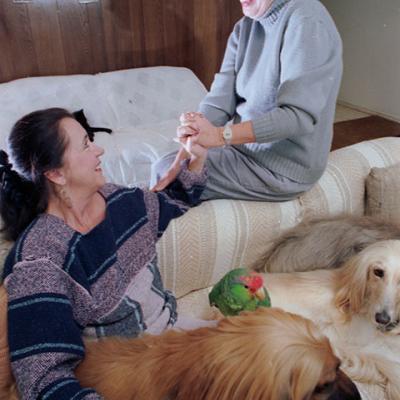 Natasha Noble and Linda Leithner sitting on couch with 2 dogs