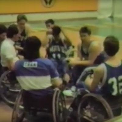 wheelchair basketball players in huddle with coach